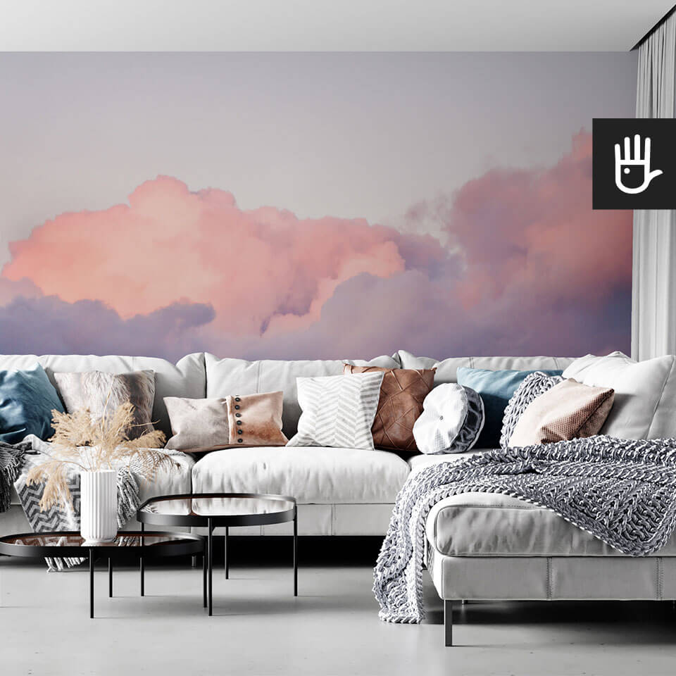 wnętrze salonu w stylu boho z kanapą z kolorowymi poduszkami na tle tapety ściennej z chmurami Fototapeta Różowe obłoki