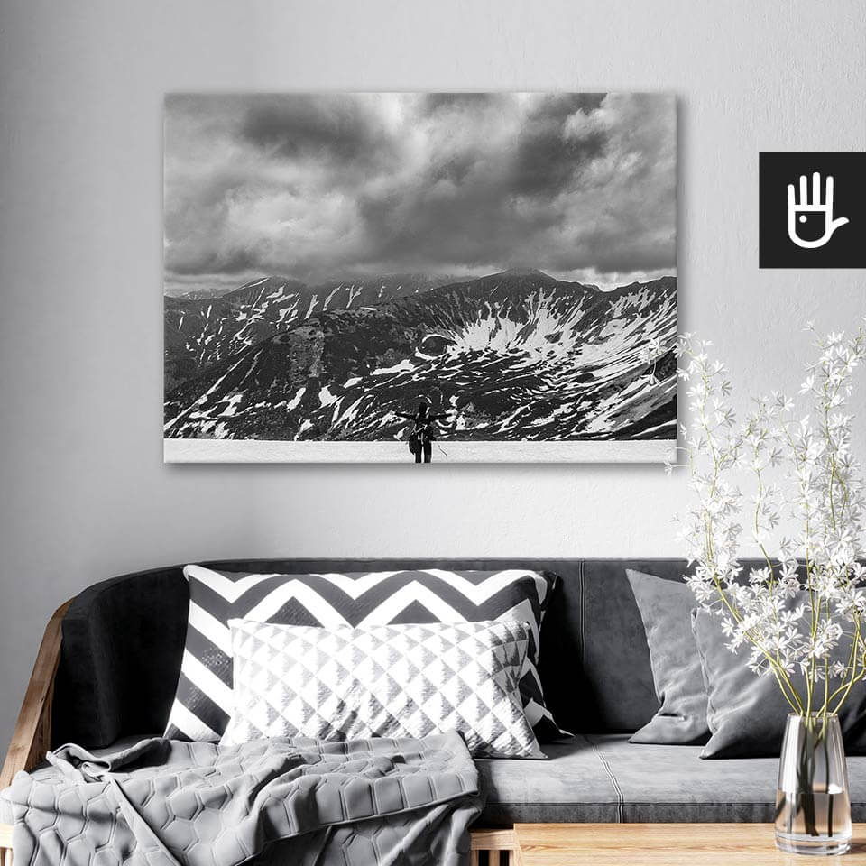 wnętrze salonu z obrazem na płótnie Śnieg w Tatrach, który wisi na ścianie za kanapą z poduszkami