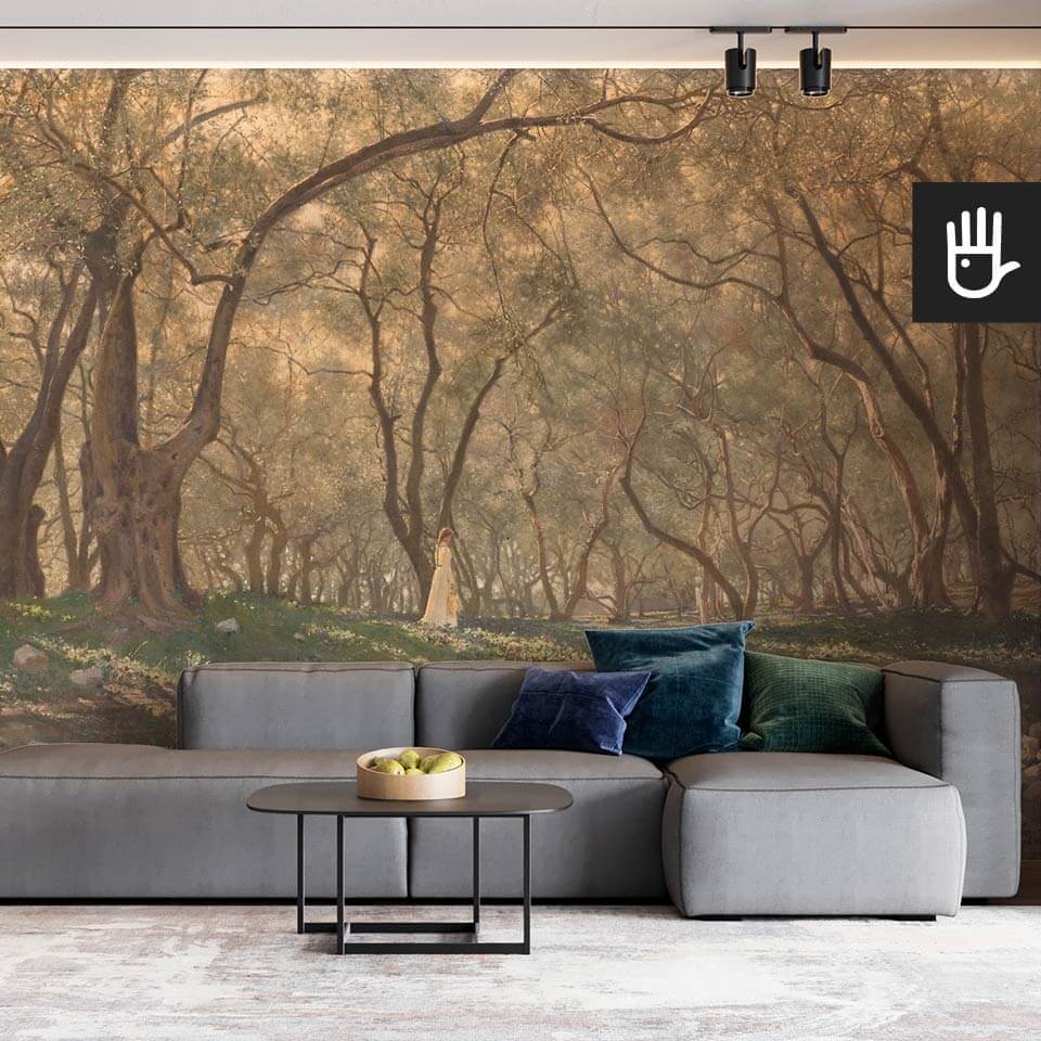 Wnętrze stylowego salonu z szarą kanapą na tle ściany z fototapetą pod oliwnymi drzewami z lasem w słońcu