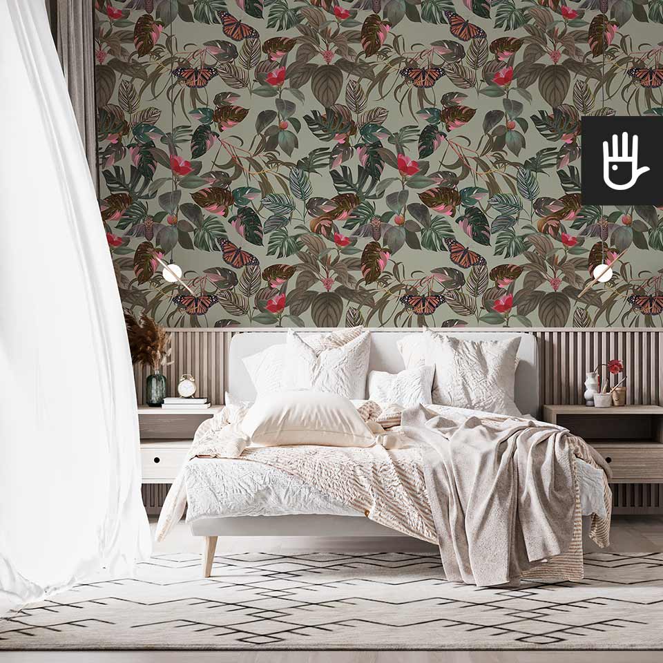 Jasna sypialnia z białym łóżkiem na tle tapety z tropikalnymi liśćmi w kolorze oliwkowej zieleni