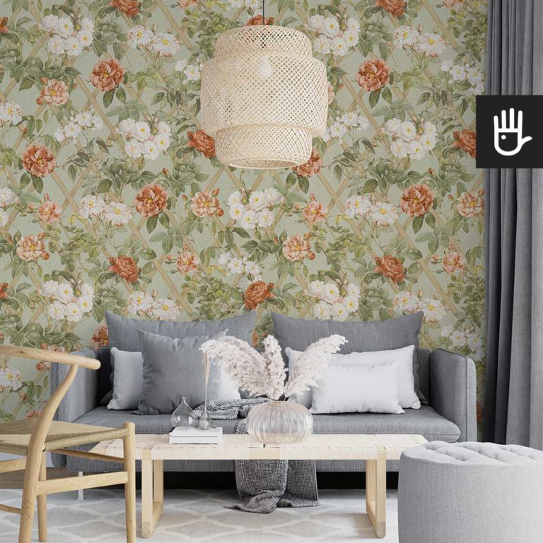 Nowoczesny salon z elementami boho z tapetą w herbaciane róże na tle w kolorze szałwiowej zieleni.