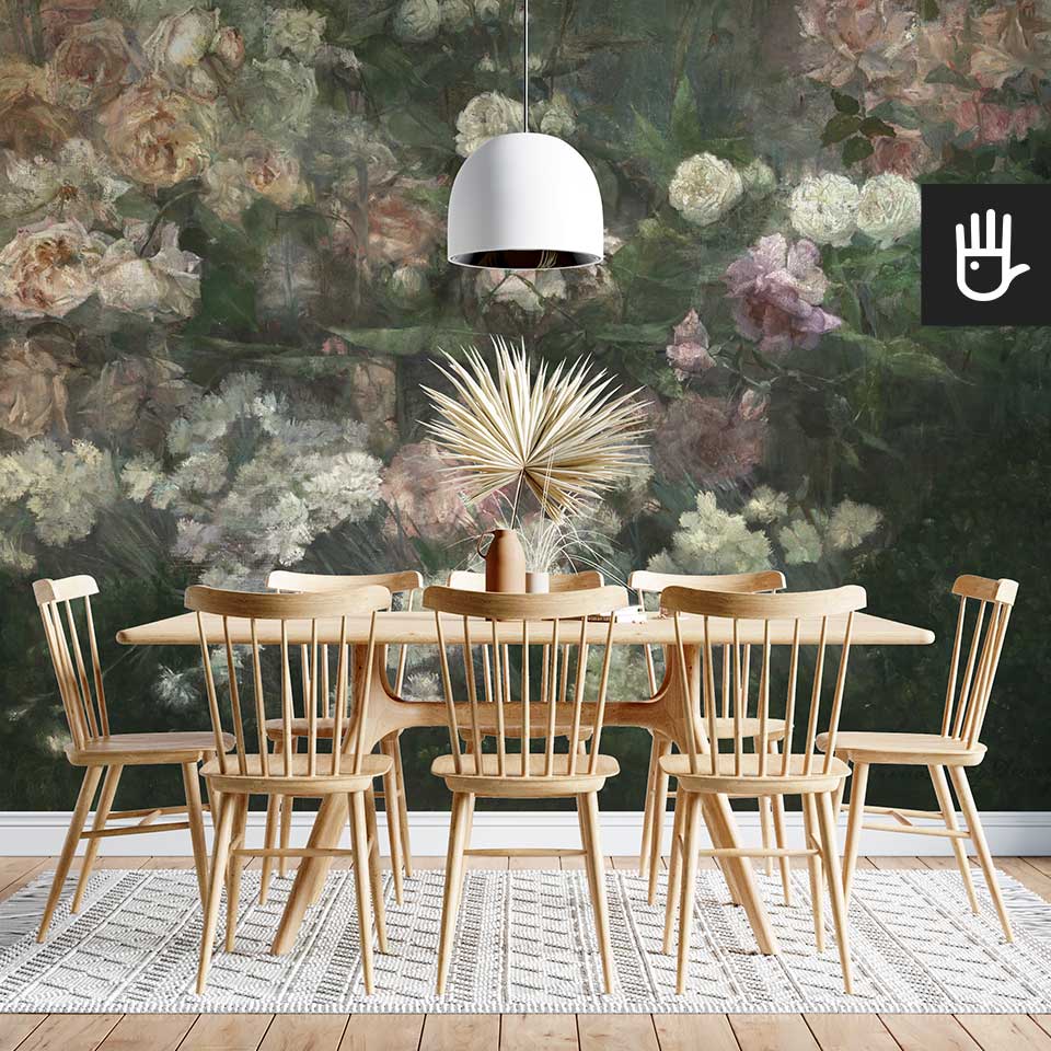 Jadalnia w naturalnym stylu z drewnianym stołem ze ścianą na której znajduje się fototapeta majowy ogród różany z dużymi kwiatami róż w kolorze butelkowej zieleni