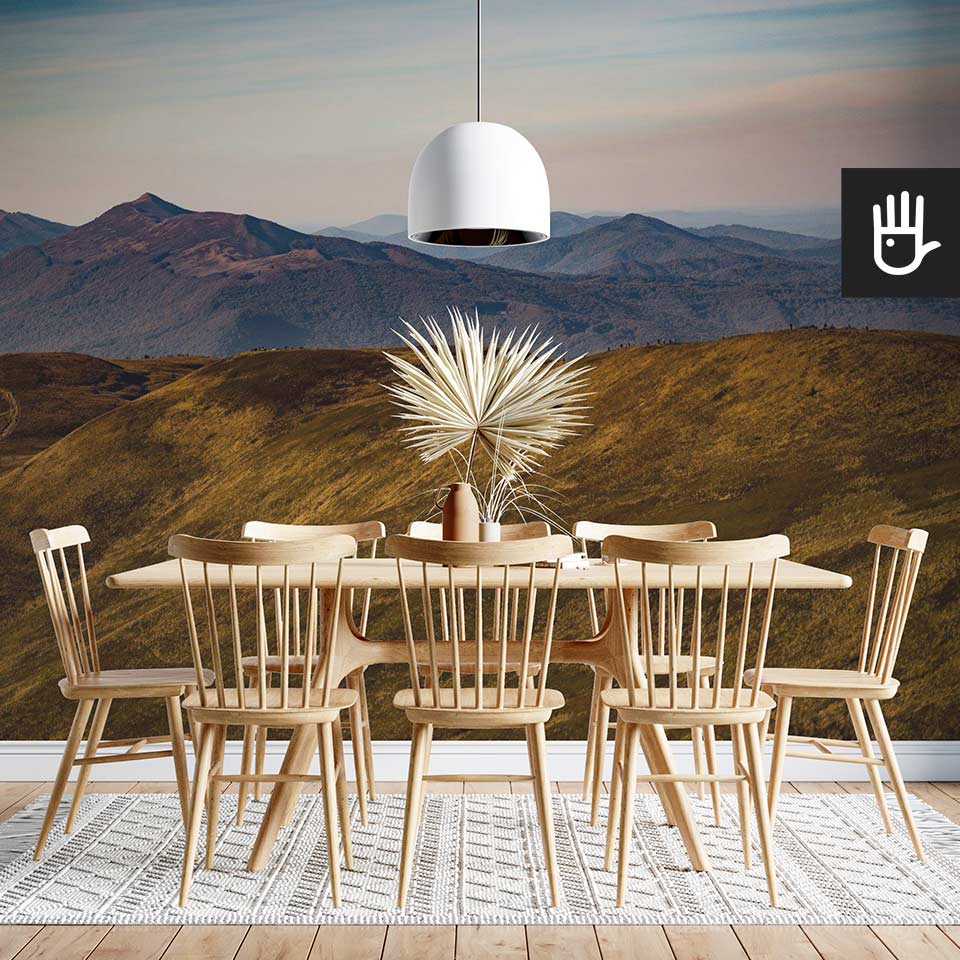 Fototapeta Górskie wędrówki z widokiem gór na ścianie w jadalni z drewnianym stołem w górskim klimacie.