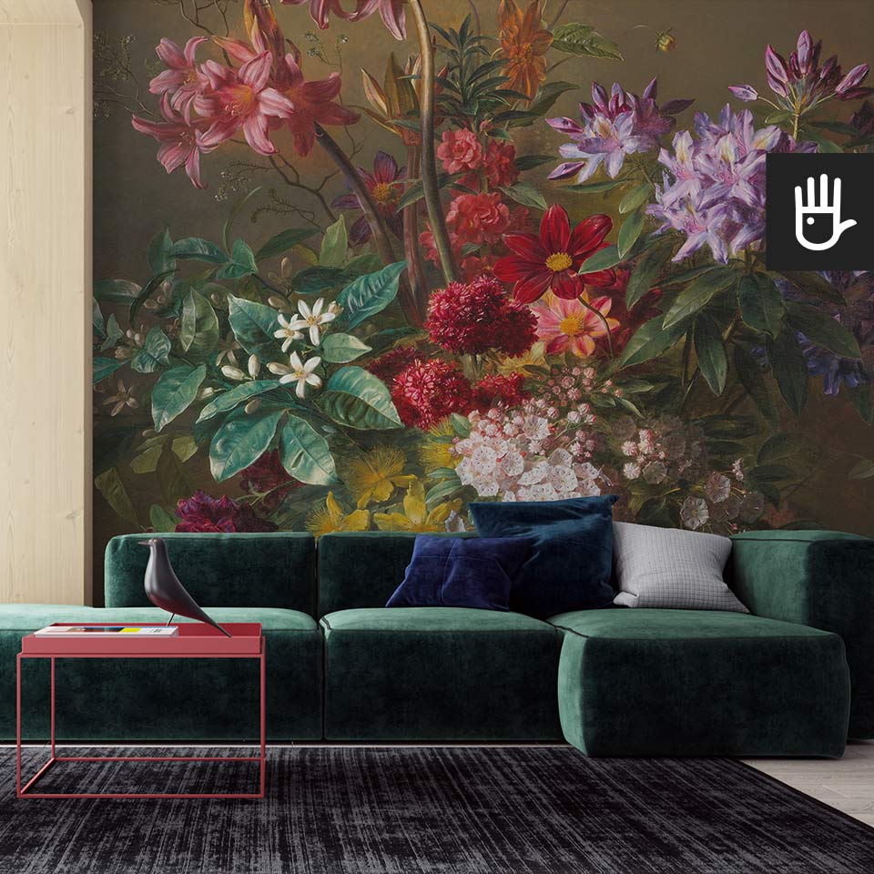Stylowy nowoczesny salon z zieloną kanapą i czerwonym stolikiem kawowym na tle ściany z dekoracją w formie fototapety bukiet wonnych kwiatów z florystycznym motywem