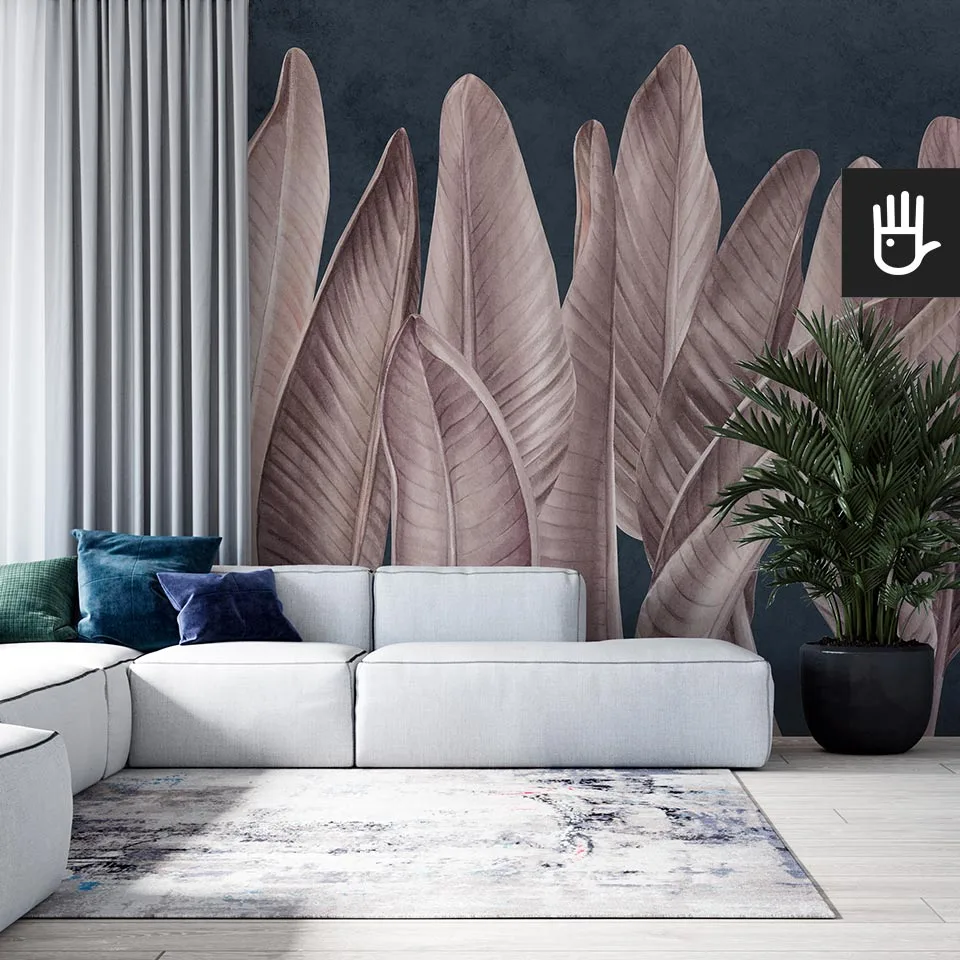 Nowoczesny salon modern z szarą kanapą na tle ściany z dekoracją ścienną, którą jest fototapeta Klasyczne różowe liście na granatowym tle w artystycznym klimacie