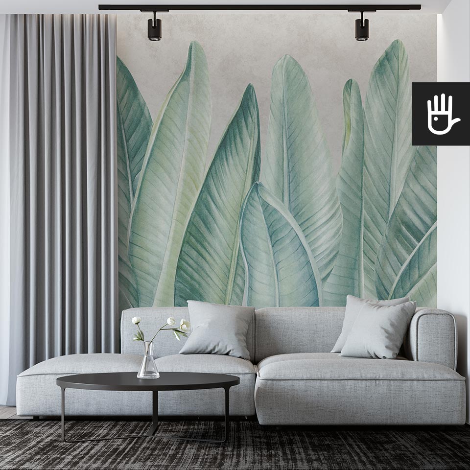 Nowoczesny salon modern z szarą kanapą na tle ściany z dekoracją ścienną, którą jest fototapeta Klasyczne zielone liście na szarym tle w artystycznym klimacie