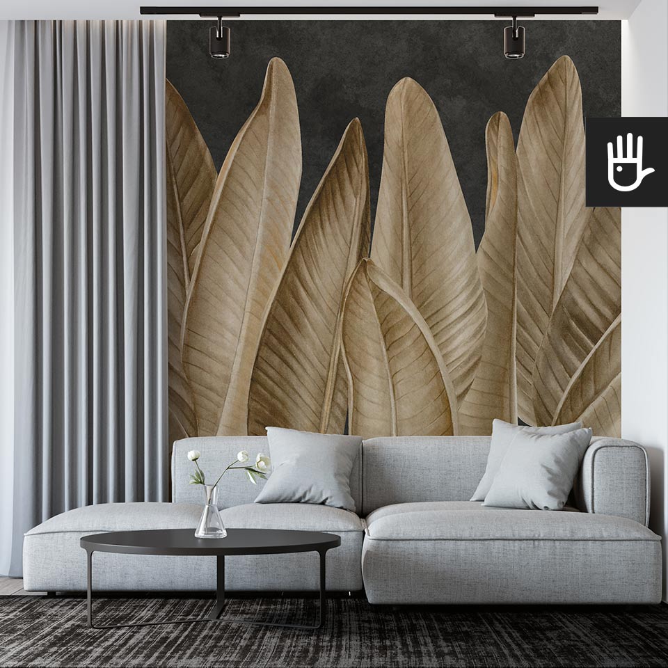 Nowoczesny salon modern z szarą kanapą na tle ściany z dekoracją ścienną, którą jest fototapeta Klasyczne złote liście na czarnym tle w artystycznym klimacie
