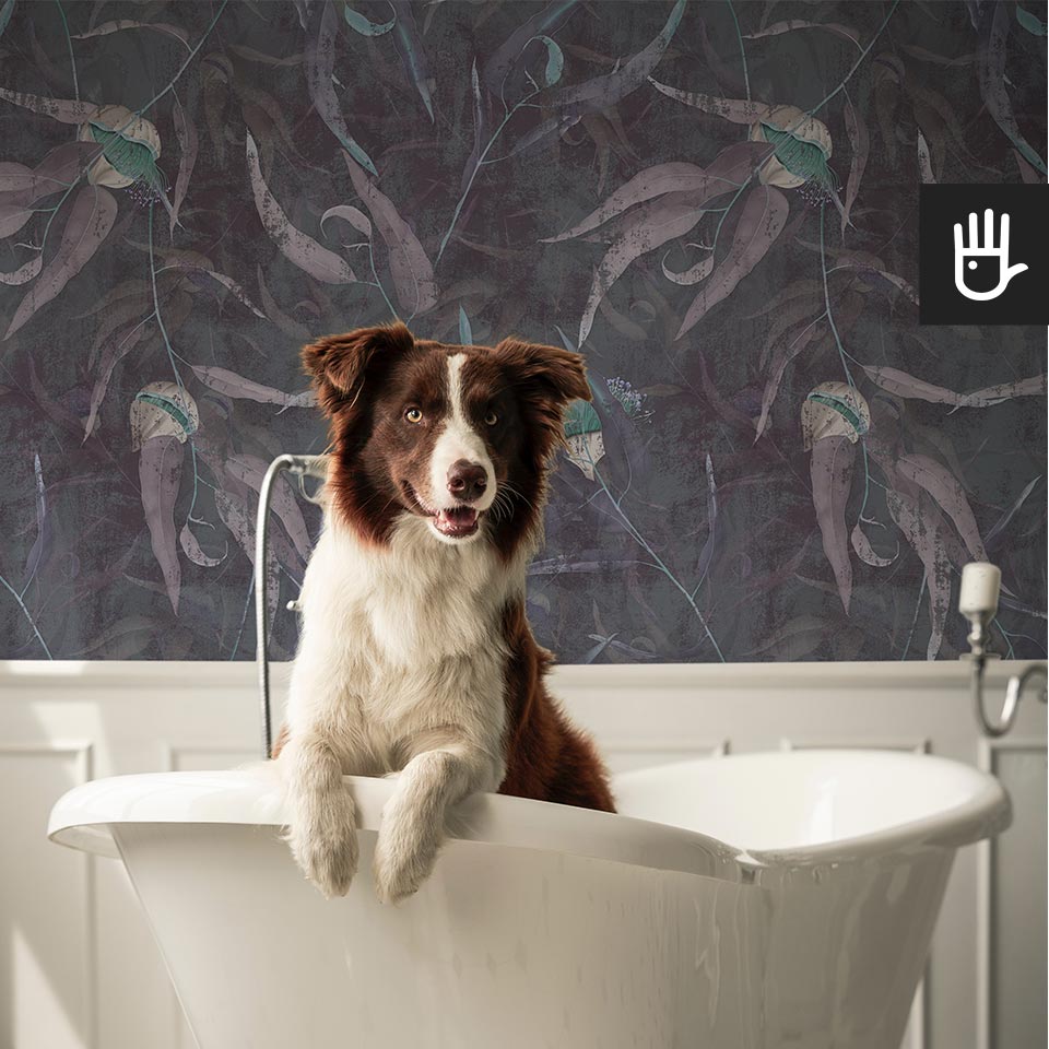 Klasyczna łazienka z wanną wolnostojącą, z białymi sztukateriami i dekoracją ściany, którą jest tapeta Turkusowe kwiaty eukaliptusa na ciemnoniebieskim tle.