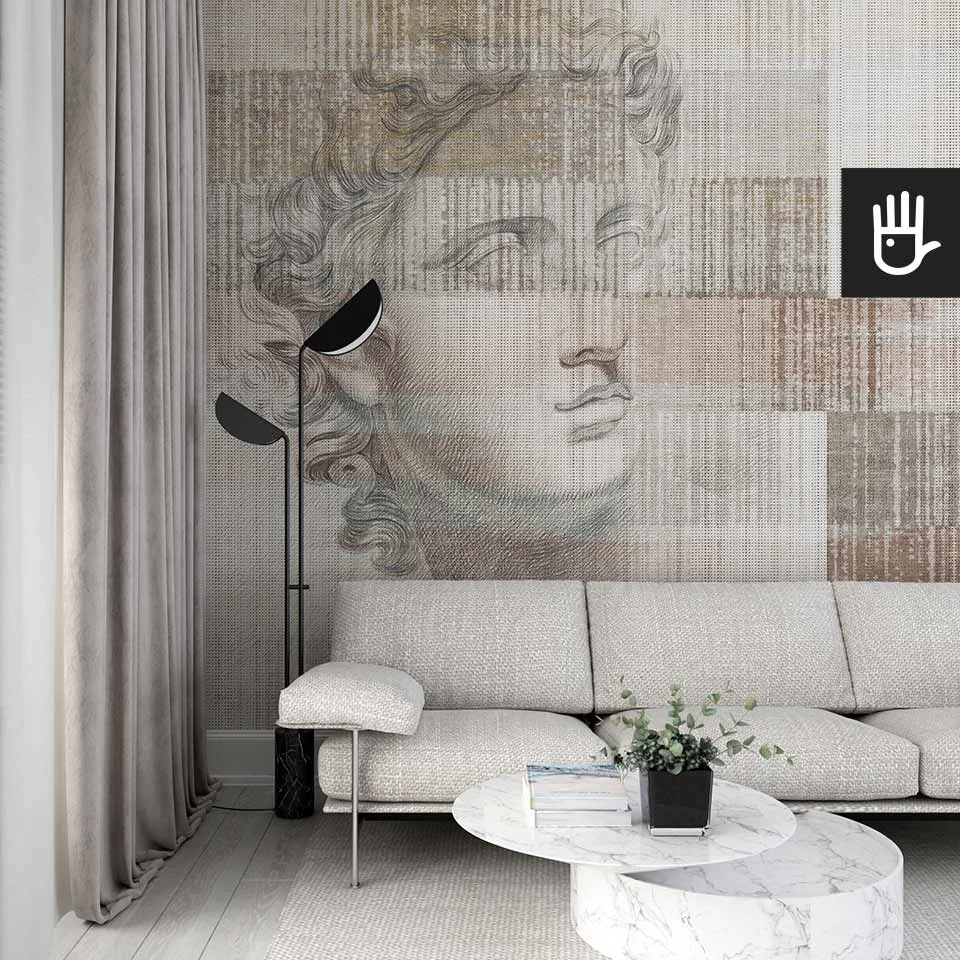 Stylowy salon z jasną kanapą i marmurowym stolikiem w otoczeniu pięknej fototapety Apollo z antycznym posągiem na na tle beżowo - brązowego dywanowego deseniu.