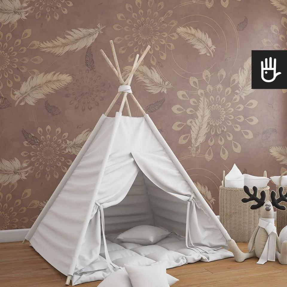Pokój dziecięcy w stylu boho z przytulnym tipi na środku i dekoracyjnym pluszowym reniferem. Na tle tapeta w kolorze brązu z delikatnymi piórkami