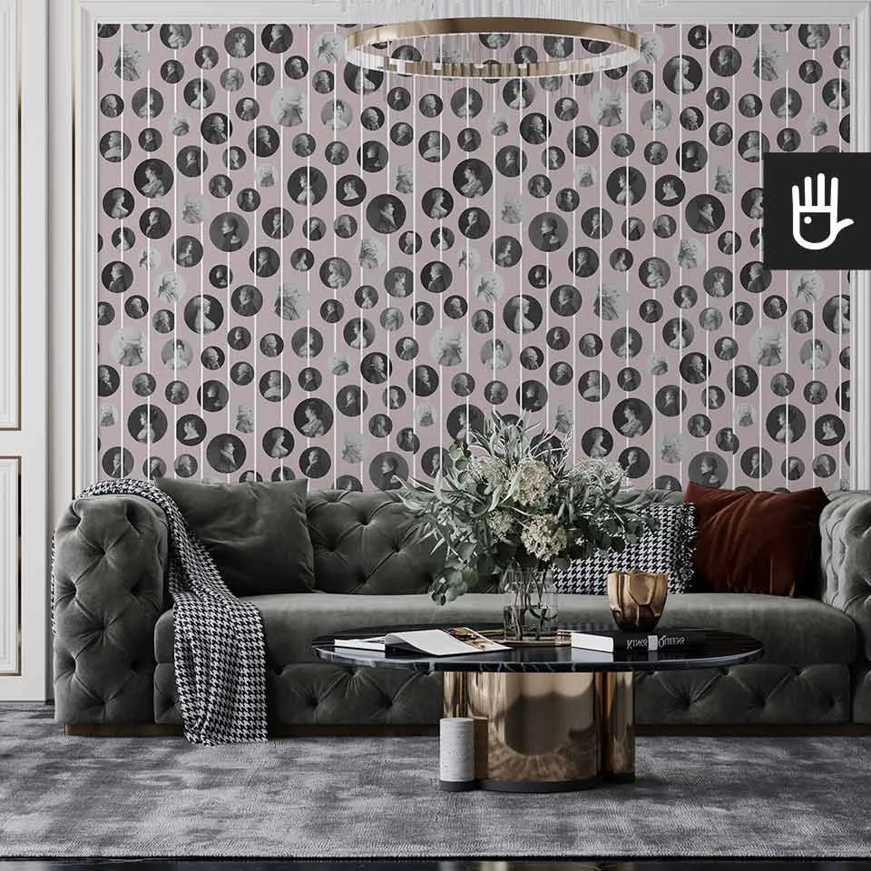 Klasyczny salon z szara pikowaną kanapą, urządzony w stylu glamour z wieloma złotymi dodatkami na tle tapety z podobiznami arystokratów