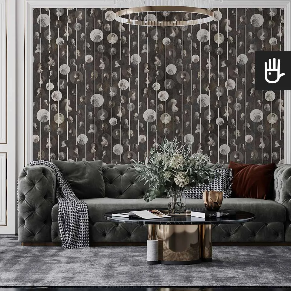 Klasyczny salon z szara pikowaną kanapą, urządzony w stylu glamour z wieloma złotymi dodatkami na tle tapety z podobiznami arystokratów