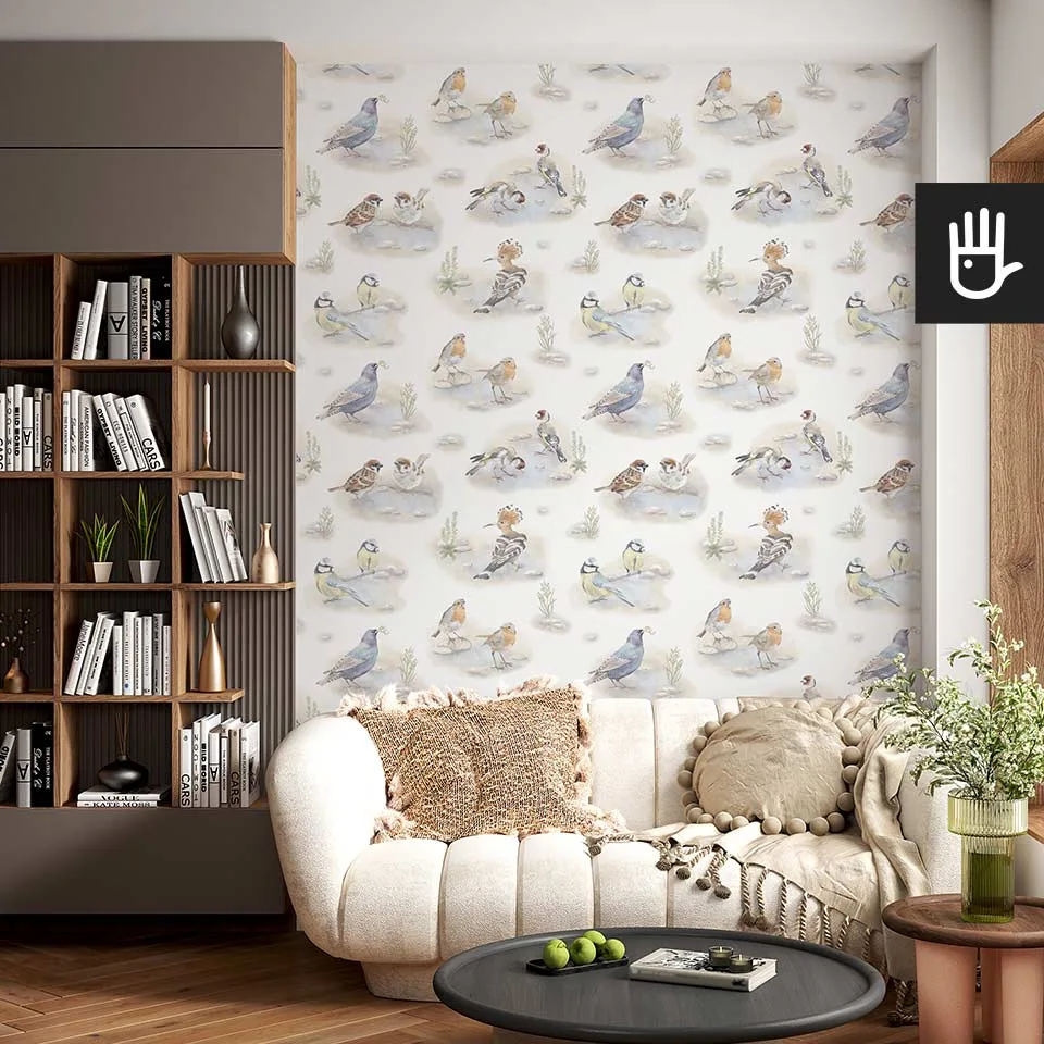 Jasny salon w stylu boho z małą beżową kanapą i wieloma dekoracjami na tle fototapety z polnymi kolorowymi ptakami