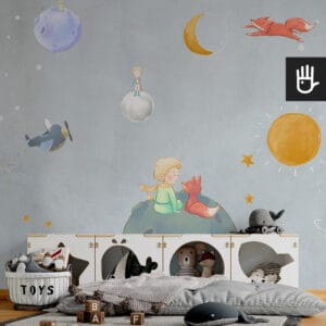 Przytulny pokój zabaw dla dzieci z szafkami na zabawki i wieloma zabawkami w naturalnych kolorach na tle tapety z ilustracjami małego księcia