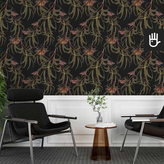 Czarne fotele w korytarzu ze szklanym stolikiem z dekoracyjną ścianą w motyle w liściach na czarnym tle