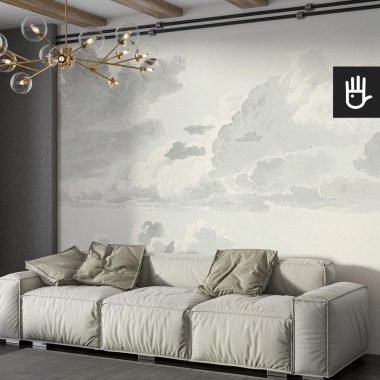 Salon w stylu boho z beżową kanapą ozdobioną zielonym poduszkami na tle fototapety z akwarelowymi chmurami