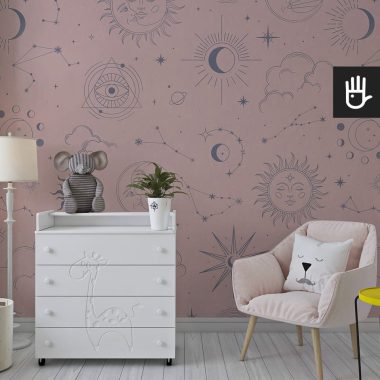 Dziecięcy pokój z białą komodą i dekoracyjnym różowym fotelem na tle tapety astro róż w granatowe wzory