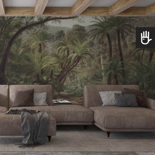 Przytulny salon z dużą brązową kanapą i drewnianymi dodatkami, na tle fototapety z tropikalnym lasem