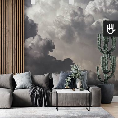 Nowoczesny salon z dużą kanapą i dekoracyjnym kaktusem na tle ściany z lamelami i fototapetą w chmury