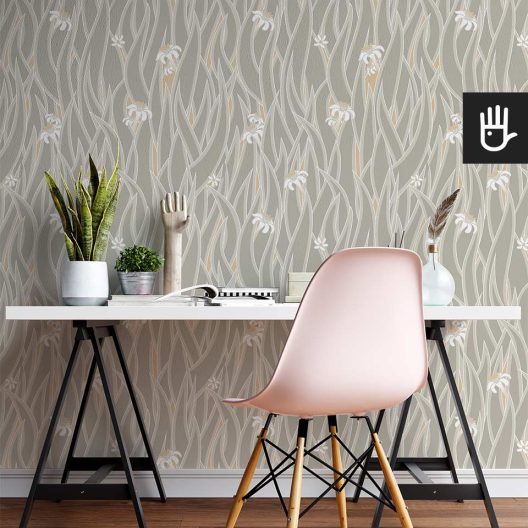 Nowoczesne biurko na metalowych nogach z różowym plastikowym krzesłem i dekoracjami na tle tapety w kwiatowy wzór