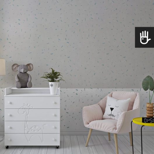 Dziecięcy pokój z białą komodą i dekoracyjnym różowym fotelem na tle fototapety z niebieskie i szare plamki