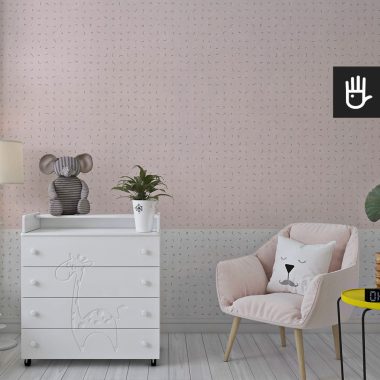 Dziecięcy pokój z białą komodą i dekoracyjnym różowym fotelem na tle fototapety z różowym i białym pasem ozdobionymi nieregularnymi kreskami