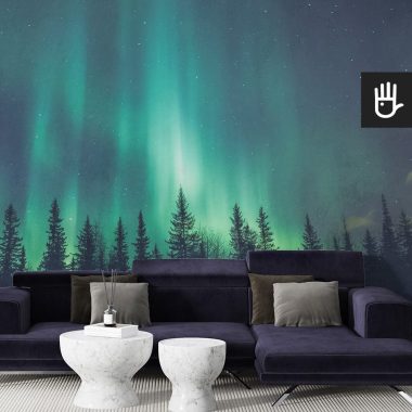 Nowoczesny salon z dużą granatową kanapą i dekoracyjnymi stolikami z marmuru na tle fototapety z lasem i nocnym niebem