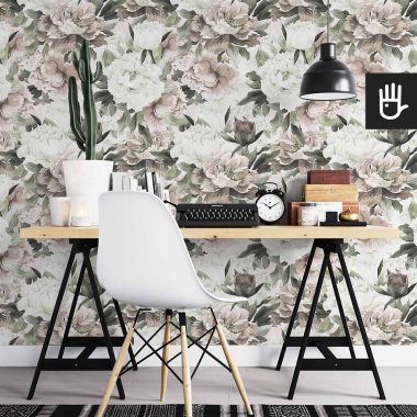 Domowe biuro z biurkiem na kozłach przystawionym do ściany z nastrojową tapetą Akwarelowe kwiaty z białymi i różowymi piwoniami z akcentem zielonych listków.