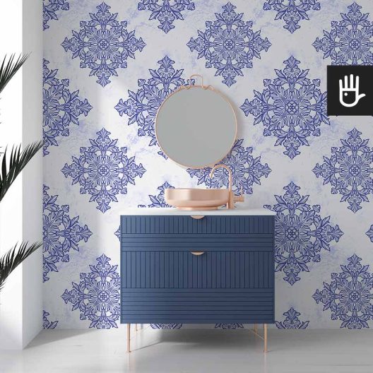 Jasna przestronna łazienka z niebieskimi meblami i złotymi dodatkami ozdobiony tapetą w kolorowy geometryczny wzór