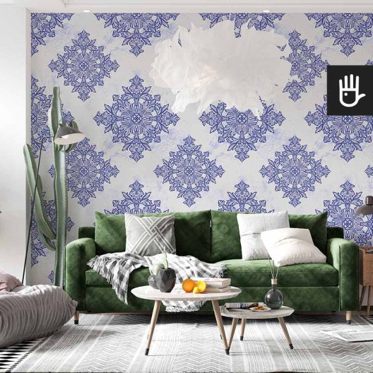 Jasny salon z zieloną kanapą i dekoracyjnym kaktusem ozdobiony jasną tapeta w kolorowy wzór geometryczny