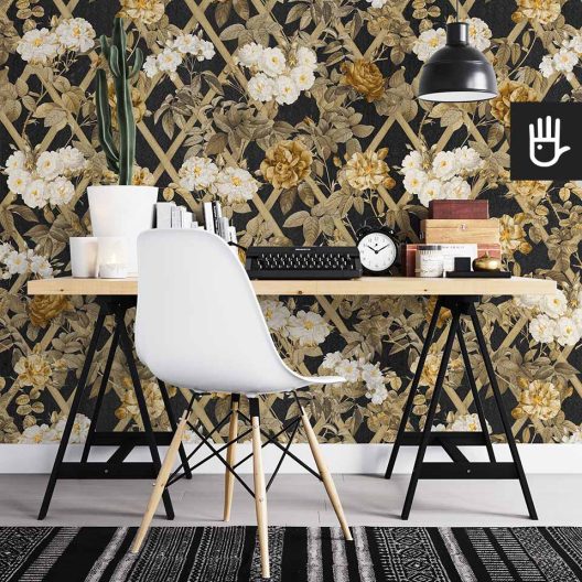 Domowe biuro z meblami ikea z dekoracją ściany, którą jest tapeta nocne rosarium z kwiatami w kolorach złota i czerni.