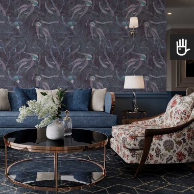 Salon w stylu Hampton z kolorową kanapą na tle ściany pokrytej granatową tapetą ścienną z malowanymi turkusowymi kwiatami eukaliptusa i fioletowymi listkami.