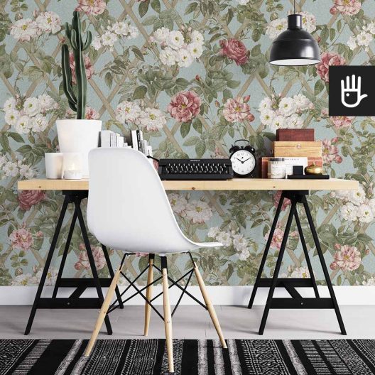 Domowe biuro z meblami ikea z dekoracją ściany, którą jest tapeta wieczorne rosarium z kwiatami w kolorach różu, zieleni i błękitu.