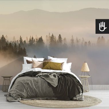 Fototapeta wschód słońca nad lasem na ścianie za łóżkiem w sypialni w stylu boho